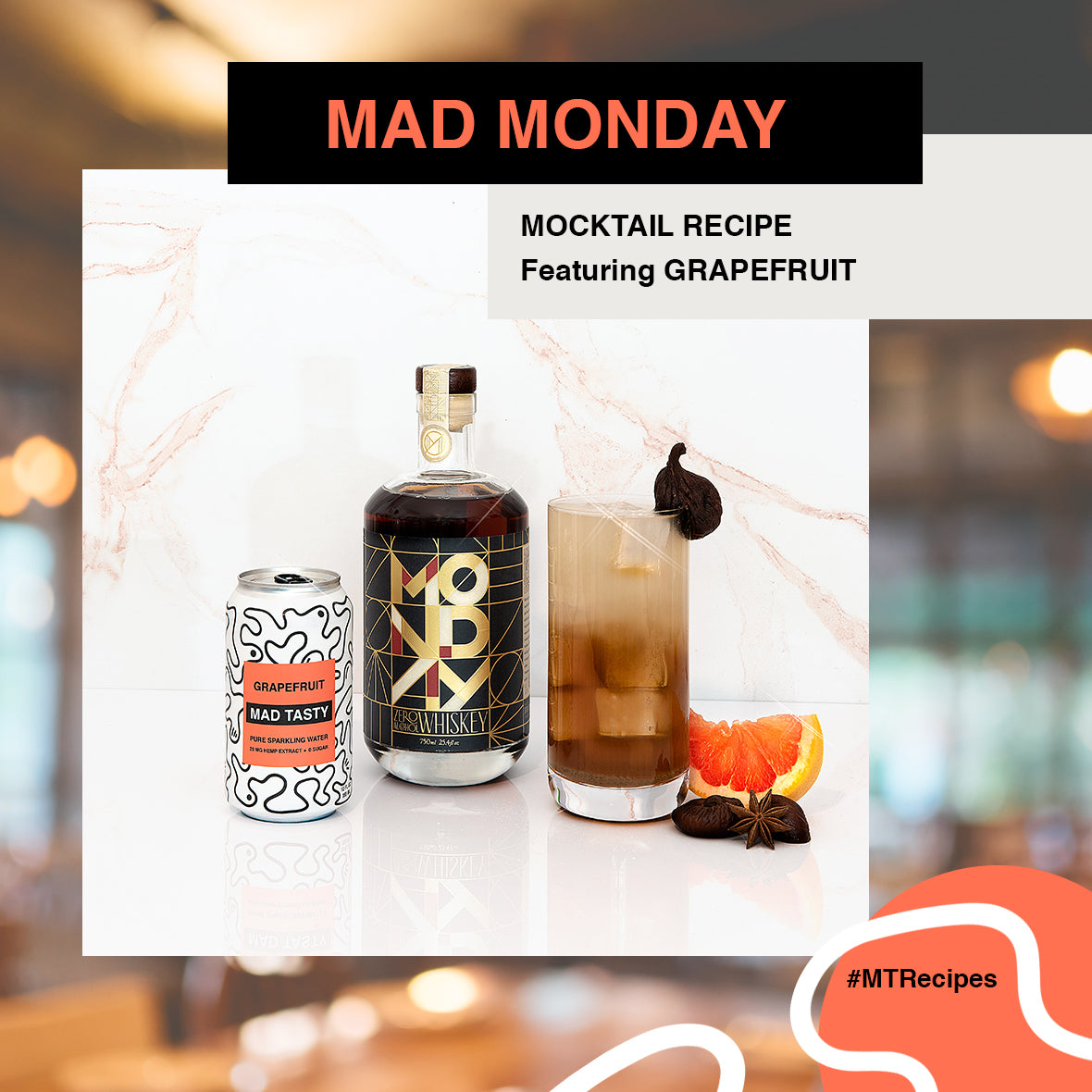 Picture of Monday zero-proof whisky, MAD TASTY Grapefruit, a glass with the mocktail in it and an orange.